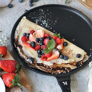 Crêpespfanne 28cm with a delicious crêpe topped with strawberries, blueberries, and raspberries on a grey surface.