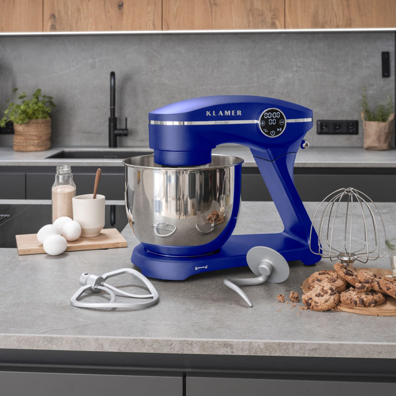 Küchenmaschine in Blau mit großem Edelstahlbehälter und Zubehör auf einer modernen Küchentheke.