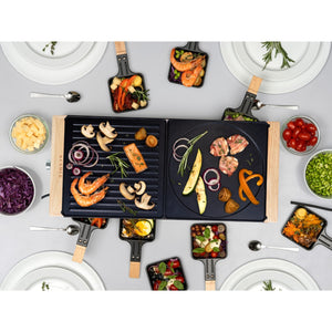 Raclette Grill Holz-Edelstahl mit verschiedenen Zutaten und Beilagen auf dem Tisch für geselliges Essen.