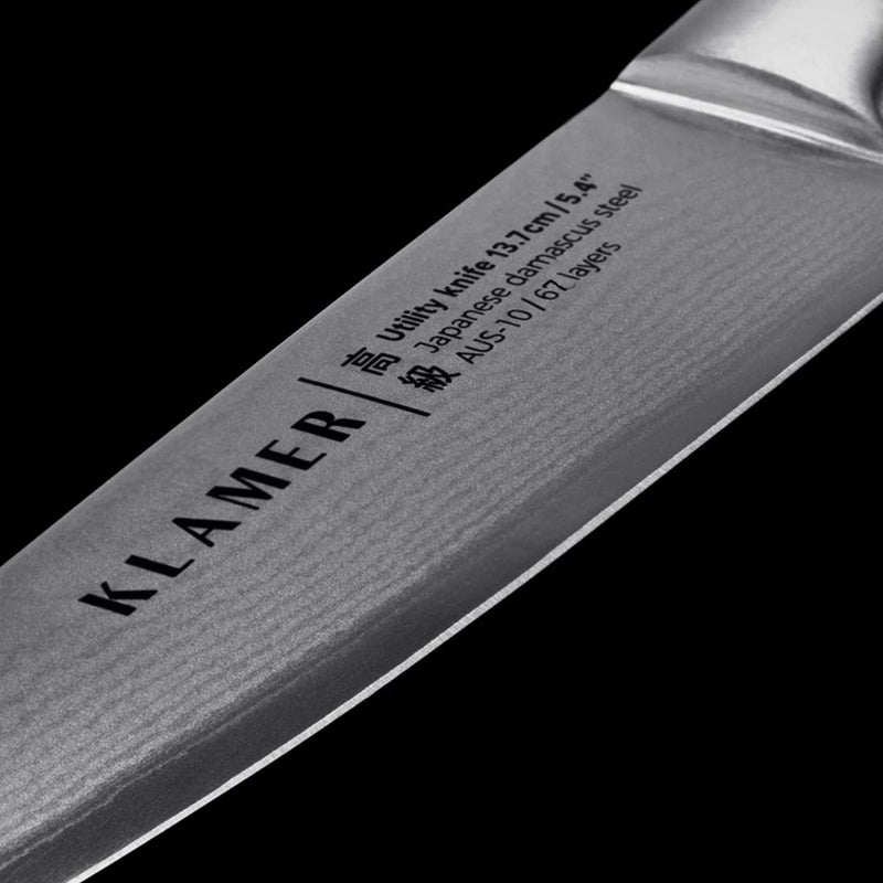 Damast Allzweckmesser 13.7cm blade detail showing Japanese Damascus steel and brand engraving.