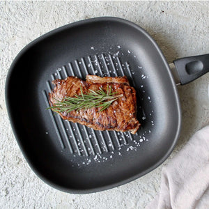 Gegrilltes Fleisch in Grillpfanne 28cm mit Rillen für fettfreies Kochen und optimaler Wärmeverteilung.