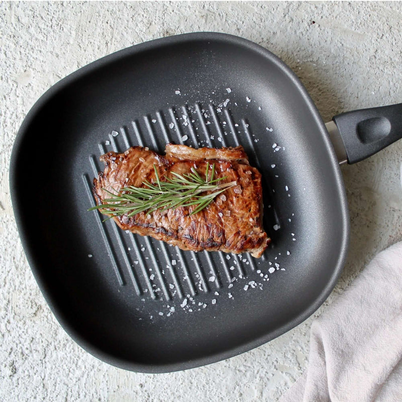 Gegrilltes Fleisch in Grillpfanne 28cm mit Rillen für fettfreies Kochen und optimaler Wärmeverteilung.